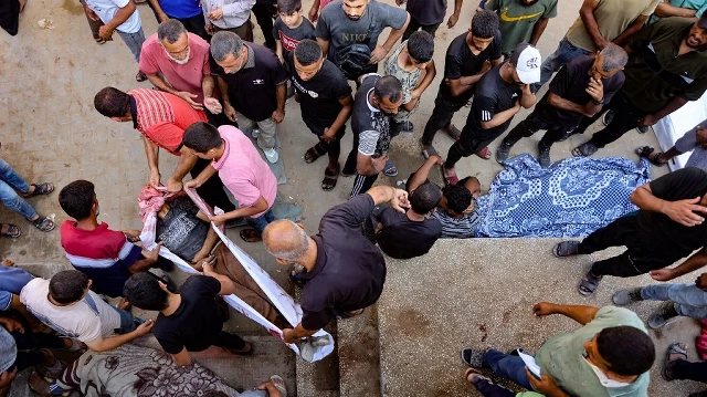 Des personnes transportent le corps d'un Palestinien tué plus tôt lors d'une frappe israélienne, dans la cour de l'hôpital al-Shifa à Gaza, le 7 septembre 2025.