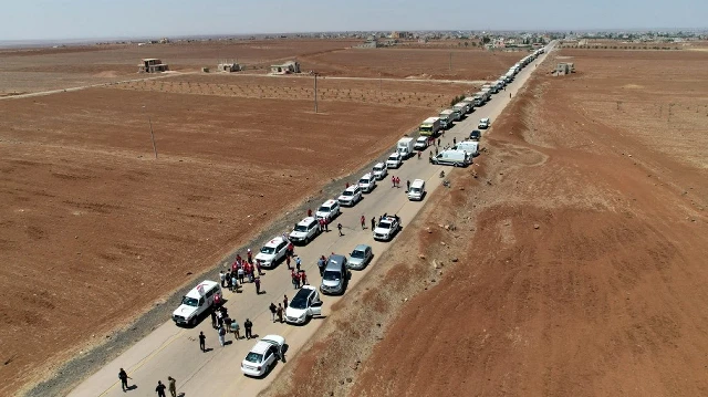Des camions du Croissant-Rouge syrien transportant de l'aide humanitaire arrivant à Busra al-Sham, dans la province de Deraa, dans le sud de la Syrie, avant de traverser la zone tampon pour rejoindre la province de Sweida.