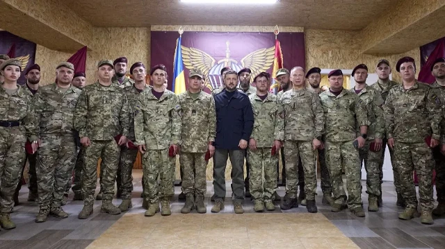 Une photo prise et diffusée par le service de presse présidentiel ukrainien le 18 septembre 2025 montre le président ukrainien Volodymyr Zelensky (au centre) posant pour une photo avec des soldats ukrainiens sur les positions de première ligne, dans un lieu non divulgué, dans la région de Donetsk, alors que la Russie envahit l'Ukraine.