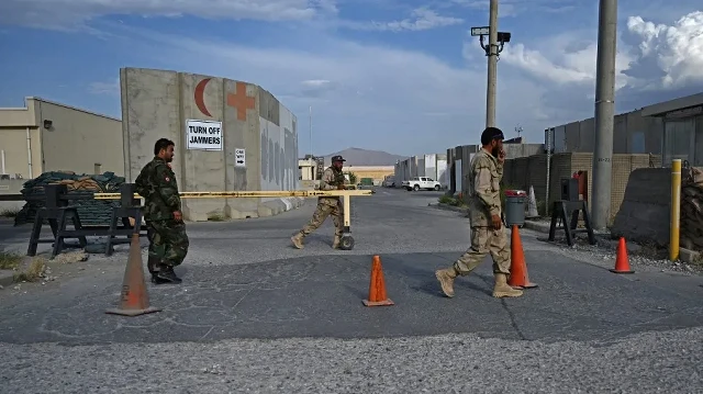 Des soldats de l'armée nationale afghane (ANA) marchent devant l'entrée d'un hôpital situé à l'intérieur de la base aérienne américaine de Bagram, à environ 70 km au nord de Kaboul, le 5 juillet 2021, après le départ de toutes les troupes américaines et de l'OTAN.