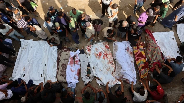Des proches entourent des sacs mortuaires contenant les corps de Palestiniens, certains tués lors de frappes israéliennes tôt le matin et d'autres tués la veille alors qu'ils cherchaient de l'aide humanitaire près de Zikim, à l'ouest de Beit Lahia, dans la cour de l'hôpital al-Shifa à Gaza, le 7 septembre 2025.