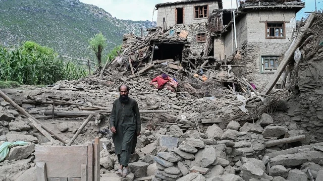 Un Afghan passe devant une maison endommagée à la suite des tremblements de terre qui ont frappé le village de Mazar Dara, dans le district de Nurgal, province de Kunar, dans l'est de l'Afghanistan, le 1er septembre 2025.