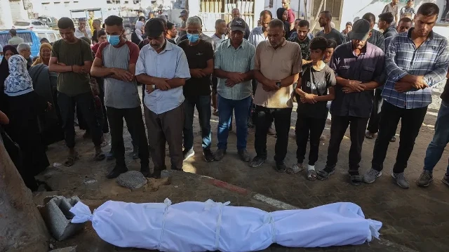 Des Palestiniens prient devant le corps enveloppé d’une personne tuée lors de frappes israéliennes sur la ville de Gaza à l’aube, à l’hôpital Al-Shifa, le 2 septembre 2025.