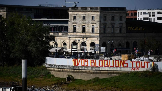 Graffiti indiquant "10 septembre bloquons tout" peint sur un mur autour d’un chantier le long de la Garonne, à Bordeaux, dans le sud-ouest de la France, 25 août 2025.