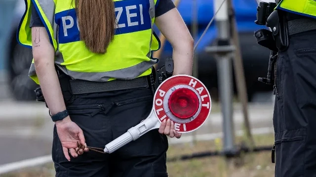 Un officier de police allemand tient un disque de signalisation lors des contrôles à la frontière germano-polonaise à Francfort-sur-l'Oder, Brandebourg, Allemagne de l'Est, le 7 juillet 2025. 