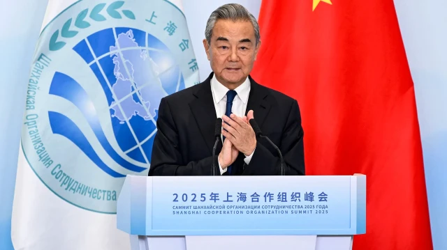 Le ministre chinois des Affaires étrangères Wang Yi applaudit lors d'une conférence de presse conjointe avec le secrétaire général de l'Organisation de coopération de Shanghai (OCS) Nurlan Yermekbayev, lors du sommet de l'OCS à Tianjin, le 1er septembre 2025.