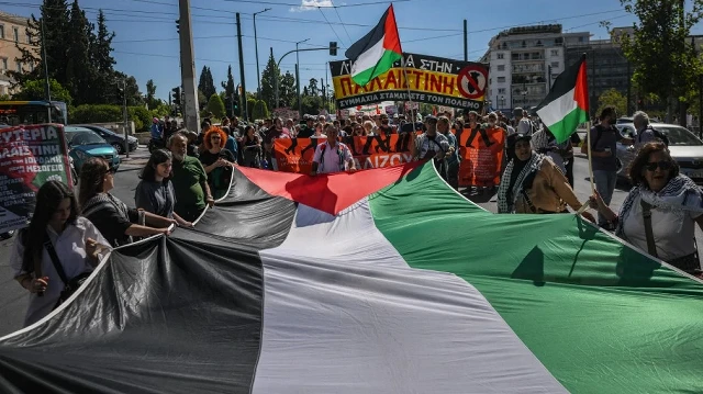 Des manifestants brandissent un grand drapeau palestinien lors d'une manifestation pour réclamer la liberté pour la Palestine, à Athènes, le 20 septembre 2025.