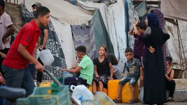 Des Palestiniens déplacés font la queue pour obtenir de l'eau dans le camp de réfugiés de Bureij, dans le centre de la bande de Gaza, le 21 septembre 2025.