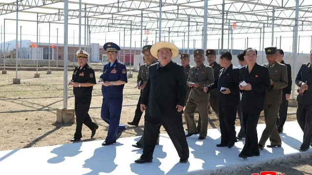 Cette photo prise le 18 septembre 2025 et publiée par l'agence de presse officielle nord-coréenne Korean Central News Agency (KCNA) via KNS le 19 septembre 2025 montre le dirigeant nord-coréen Kim Jong Un (au centre) inspectant la construction d'une ferme sous serre et un projet de développement régional dans la ville de Sinuiju, dans la province du Pyongan du Nord.