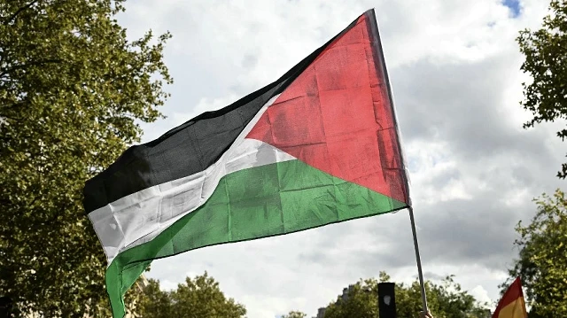 Un manifestant brandit un drapeau palestinien lors d'une marche réclamant la ”reconnaissance de l'État palestinien et la fin du génocide”, à Paris, le 21 septembre 2025.