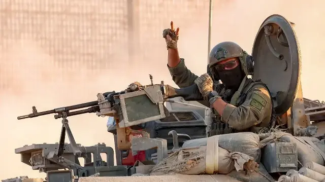 Un soldat de l’armée israélienne fait un geste alors qu’il tient la tourelle d’un véhicule de combat d’infanterie (VCI) à un poste le long de la barrière frontalière avec la bande de Gaza, dans le sud d’Israël, le 12 septembre 2025.