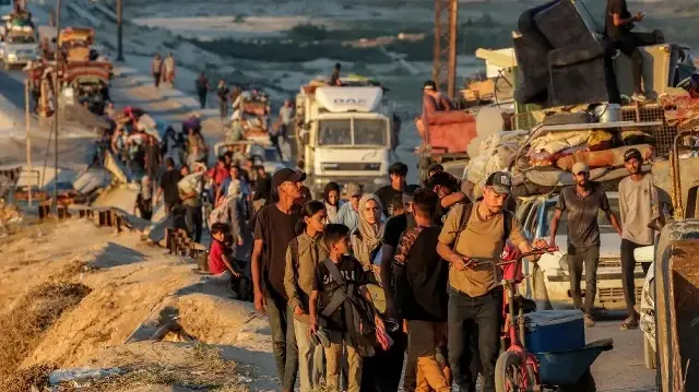 Des Palestiniens déplacés, fuyant Gaza-ville vers le sud, se déplacent à pied et en véhicule le long de la route côtière à Nuseirat, dans le centre de la bande de Gaza, le 13 septembre 2025.