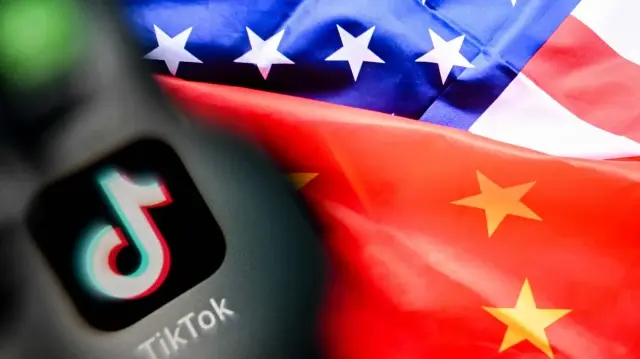 Logo du réseau social chinois TikTok sur l’écran d’un smartphone et une illustration combinant les drapeaux des États-Unis et de la Chine sur l’écran d’un ordinateur portable à Francfort-sur-le-Main, dans l’ouest de l’Allemagne,  10 avril 2025.