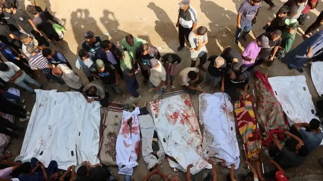 Des proches entourent des sacs mortuaires contenant les corps de Palestiniens, certains tués lors de frappes israéliennes tôt le matin et d'autres tués la veille alors qu'ils cherchaient de l'aide humanitaire près de Zikim, à l'ouest de Beit Lahia, dans la cour de l'hôpital al-Shifa à Gaza, le 7 septembre 2025.