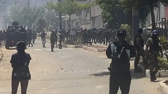 Les forces de sécurité se tiennent sur la route alors que des manifestants se rassemblent lors d'une manifestation contre les coupures répétées d'eau et d'électricité à Antananarivo, le 29 septembre 2025. 