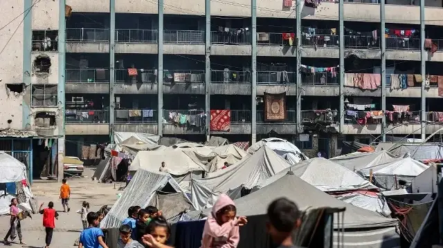 Des tentes abritant des personnes déplacées par le conflit sont installées dans la cour d'une école gérée par l'Office de secours et de travaux des Nations Unies pour les réfugiés de Palestine (UNRWA) à Khan Younes, dans le sud de la bande de Gaza, le 30 septembre 2025. 