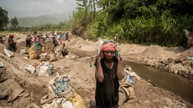 Une femme transporte un sac de sable extrait de la rivière Renga à Bweremane, le 27 février 2025.