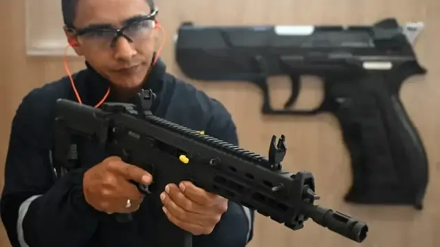 Un ingénieur tient un nouveau fusil conçu et fabriqué dans le pays par INDUMIL (industrie militaire) à l'usine d'armes et de munitions Jose Maria Cordova dans la municipalité de Soacha, près de Bogota en Colombie, le 29 septembre 2025.