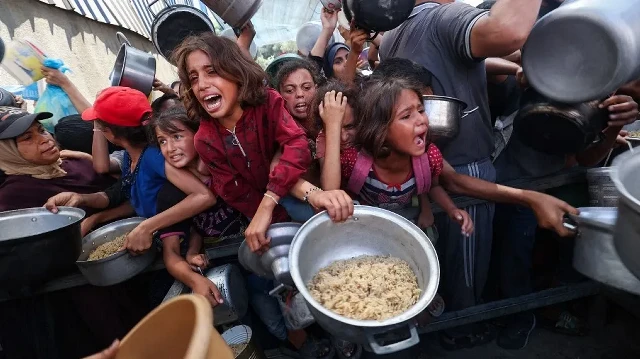 Des Palestiniens se bousculent pour recevoir un repas chaud d'une cuisine de charité dans le camp de réfugiés de Nuseirat, dans la bande de Gaza assiégée par Israël, le 4 septembre 2025, où l'ONU a déclaré la famine après près de deux ans de guerre.