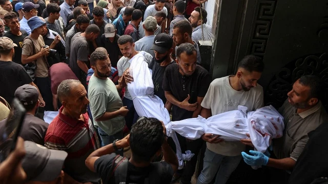 Des Palestiniens transportent les corps recouverts d'un linceul des personnes tuées lors des frappes israéliennes sur la ville de Gaza à l'aube, lors d'un cortège funèbre à l'hôpital Al-Shifa, le 4 septembre 2025, dans le contexte de la guerre entre Israël et le mouvement militant Hamas.