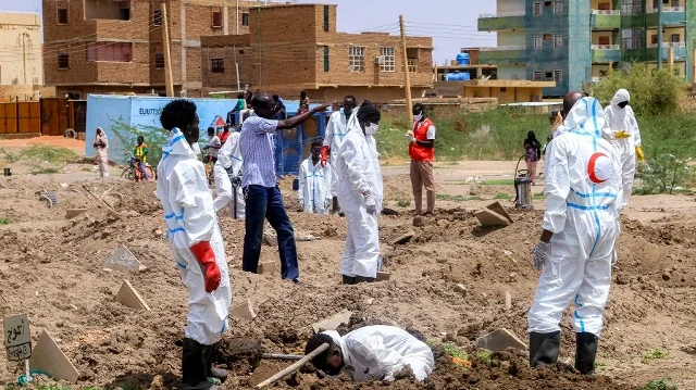 Le 2 août 2025, des membres du Croissant-Rouge soudanais et des experts médico-légaux exhument les dépouilles de personnes enterrées dans des tombes de fortune pour les réinhumer dans le cimetière local d'al-Azhari, dans la banlieue sud de Khartoum. Les morts ont été enterrés à la hâte lorsque la zone était sous le contrôle des paramilitaires des Forces de soutien rapide (RSF).