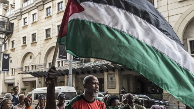 Mandla Mandela (au centre), député sud-africain et petit-fils du héros sud-africain de la lutte contre l'apartheid Nelson Mandela, danse alors qu'il participe à une manifestation pro-palestinienne devant le Sandton Convention Centre à Sandton, le 13 février 2025.