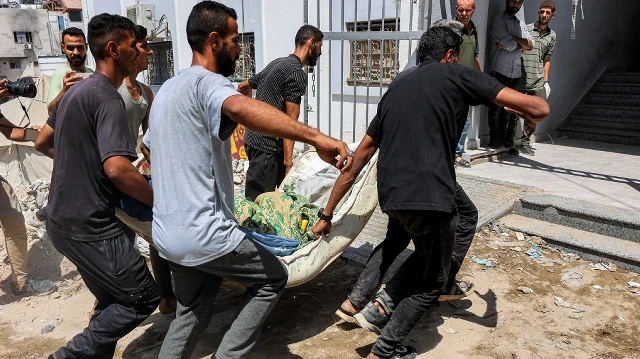 Des hommes transportent le corps d'une victime tuée par un bombardement israélien sur un campement abritant des personnes déplacées, à l'hôpital Shifa de Gaza, le 4 septembre 2025.