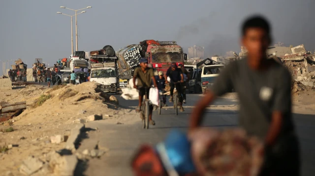 Des Palestiniens fuyant vers le sud, transportant leurs biens dans des véhicules et à vélo, sur la route côtière près du camp de réfugiés de Nuseirat, dans le centre de la bande de Gaza, le 5 septembre 2025. 