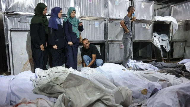 Des Palestiniens pleurent devant les corps recouverts d'un linceul de leurs proches tués lors des frappes israéliennes sur la ville de Gaza à l'aube, à la morgue de l'hôpital Al-Shifa, le 2 septembre 2025. L'agence de défense civile de Gaza a déclaré le 2 septembre que les frappes israéliennes sur un appartement et un immeuble résidentiel avaient tué 13 personnes pendant la nuit.