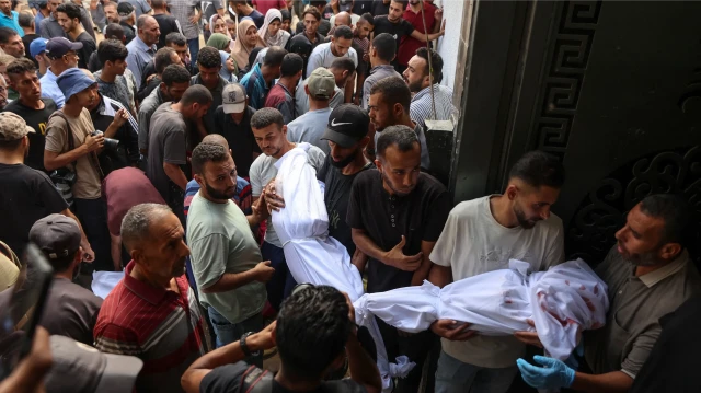Des Palestiniens transportent les corps recouverts d'un linceul des personnes tuées lors des frappes israéliennes sur la ville de Gaza à l'aube, lors d'un cortège funèbre à l'hôpital Al-Shifa, le 4 septembre 2025, dans le contexte de la guerre entre Israël et le mouvement militant Hamas. 