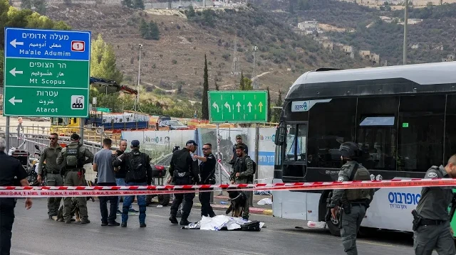 Les forces de sécurité israéliennes se rassemblent près d’un corps à côté d’un bus sur le lieu d’une fusillade au carrefour de Ramot, à Jérusalem-Est annexée par Israël, le 8 septembre 2025. 