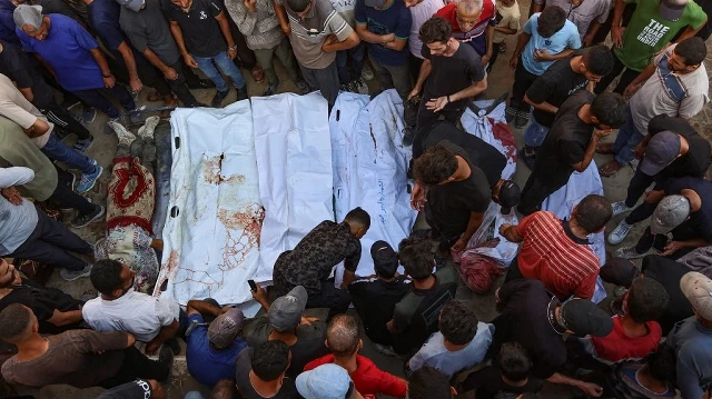 Des proches entourent des sacs mortuaires contenant les corps de Palestiniens, certains tués lors de frappes israéliennes tôt le matin et d'autres tués la veille alors qu'ils cherchaient de l'aide humanitaire près de Zikim, à l'ouest de Beit Lahia, dans la cour de l'hôpital al-Shifa à Gaza, le 7 septembre 2025.