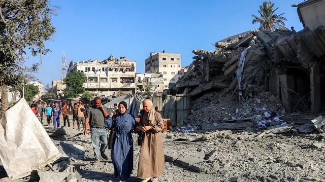 Des personnes passent devant des décombres après une frappe israélienne la veille sur la tour Salam à Gaza, le 9 septembre 2025.