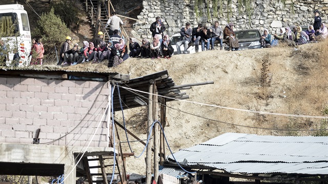 Relatives of trapped workers wait outside a coal mine collapsed due to the flooding