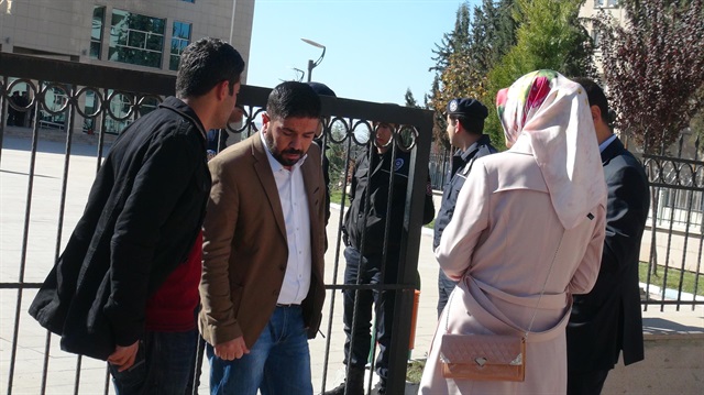 Family members of police officers, detained for illegally tapping claims, gather outside Kilis court house