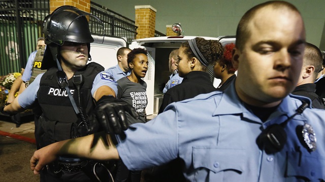 Police set up a perimeter around a  protester who is detained during a demonstration at a Walmart store in St. Louis, Missouri, October 13, 2014. Hundreds of people demonstrated in the pouring rain in the St. Louis area on Monday, staging a series of rolling protests in the latest show of anger over the police killing of an unarmed black teenager in August. At least 50 protesters were arrested in civil disobedience acts in Ferguson, the suburb where Michael Brown, 18, was shot dead. Other groups occupied St. Louis city hall, where they tried to hang a banner, shut down a local Walmart, and chanted outside a fundraiser for a local politician.   REUTERS/Jim Young (UNITED STATES - Tags: CRIME LAW CIVIL UNREST)