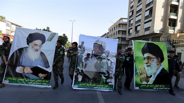 Members from Hashid Shaabi hold portraits of lawmaker and paramilitary commander Hadi al-Amiri (C), Iran's Supreme Leader Ayatollah Ali Khamenei (R) and Iraq's top Shi'ite cleric Grand Ayatollah Ali al-Sistani (L) during a demonstration to show support for Yemen's Shi'ite Houthis and in protest of an air campaign in Yemen by a Saudi-led coalition, in Baghdad March 31, 2015. Saudi troops clashed with Yemeni Houthi fighters on Tuesday in the heaviest exchange of cross-border fire since the start of a Saudi-led air offensive last week, while Yemen's foreign minister called for a rapid Arab intervention on the ground. REUTERS/Thaier Al-Sudani