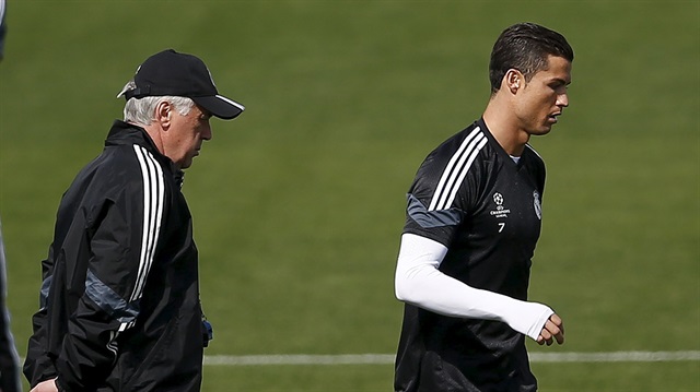 Real Madrid's coach Carlo Ancelotti (L) looks at Real Madrid's Cristiano Ronaldo during a training session in Valdebebas, outside Madrid, April 21, 2015. Real Madrid will play their Champions League quarter final second leg soccer match against Atletico Madrid at Santiago Bernabeu stadium on Wednesday. REUTERS/Andrea Comas