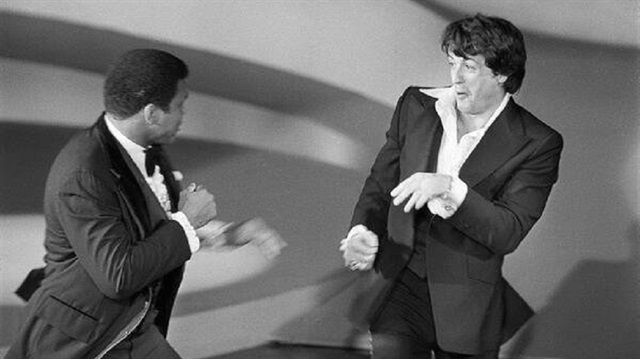 1977 Oscar Ödül Töreninden bir an... Sylvester Stallone ödül konuşması yaparken Muhammed Ali sahneye gelir ve ünlü aktörle yıllarca unutulmayacak bir atışmayı sahnelerler.