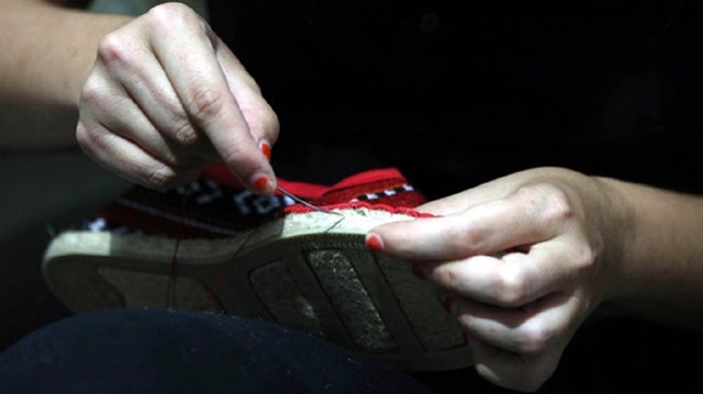 Seray Matliz, İspanyol tabanı üzerine, Filistin'in işlemeli kumaşını geçirerek ayakkabı üretiyor.