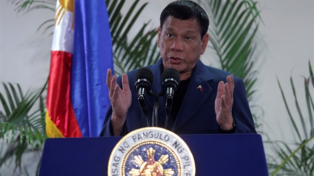 Philippine President Rodrigo Duterte interacts with reporters during a news conference upon his arrival from a four-day state visit in China at the Davao International Airport in Davao city