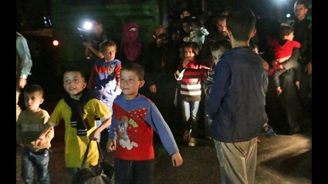 Syrians who were living in the rebel-held side of Aleppo are seen after nearly 50 people fled the rebel held eastern districts of the battered city into the government-controlled west on October 24, 2016.