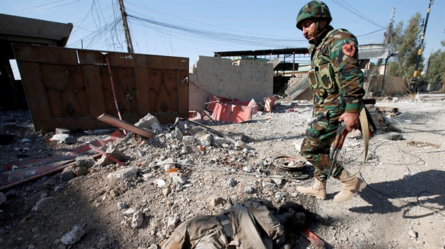 A member of Peshmerga forces walks in the town of Bashiqa, Mosul