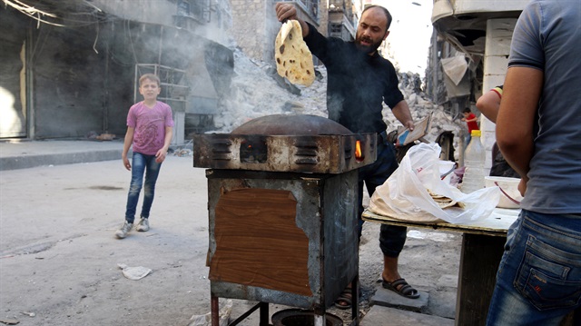 Halep'te yaşayan 300 bin sivil için hizmet veren yalnızca 3 fırın kaldı. Sokakta seyyar tezgahlarda ekmek yapan satıcılar..