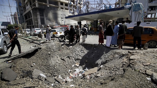 People gather at the site of a Saudi-led air strike that targeted the Complex for Automotive Services near a tunnel leading to the presidential house in Yemen's capital Sanaa