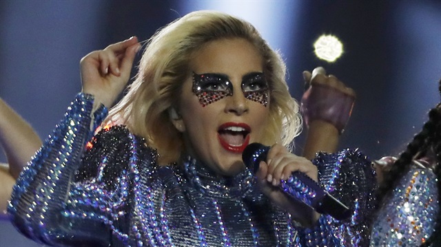 Standing atop the roof of Houston's NRG Stadium with drones illuminating an American flag in the night sky behind her, Lady Gaga kicked off her Super Bowl halftime set on Sunday by singing "God Bless America" as a subtle message of inclusion and unity in a deeply divided United States.
