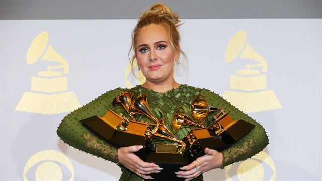 Adele holds the five Grammys she won including 'Record of the Year' for 'Hello'.