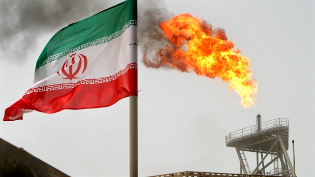 A gas flare on an oil production platforum in the Soroush oil fields is seen alongside an Iranian flag.