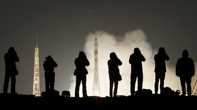 Photographers take pictures as space craft lifts off