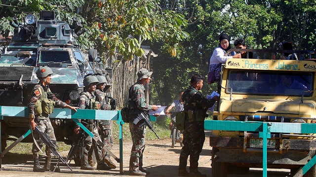 Soldiers distribute pictures of a member of extremist group Abu Sayyaf Isnilon Hapilon